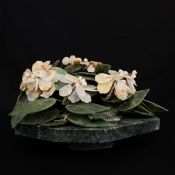 A 20th century Chinese carved spinach jade and soapstone bonsai tree raised on a naturalistic marble