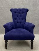A 19th century button back library armchair having a splayed scrolling back with curved arms over