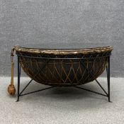 A large Middle Eastern kettle drum converted into a coffee table with a protective glass top