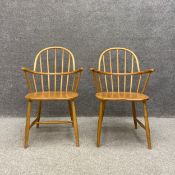 A pair of mid century Ercol style beech and elm Windsor chairs with impressed Utility Scheme