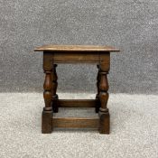 An early 19th century jointed oak stool having a rectangular thumb moulded seat raised on four
