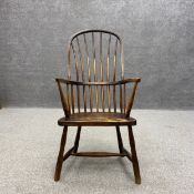 A 19th century elm stick back Windsor armchair having a high hooped back with outswept arms over a