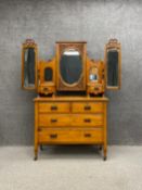 A C.1900 walnut dressing chest having a central oval pier style mirror with a bevelled plate and