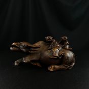 A finely carved late 19th century Chinese hardwood figure group of two children riding a recumbent