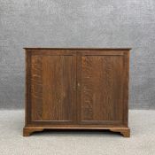 A 19th century oak side cabinet having a rectangular moulded top over two panelled doors opening