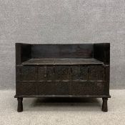 An early 20th century ebonised Indian hardwood dowry chest settle having a square back and arms