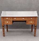 A Victorian pine washstand having a white marble top with a shaped gallery back over an