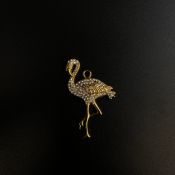A gold plated flamingo pendant encrusted with cubic zircona stones.