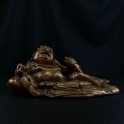 A finely carved late 19th century Chinese hardwood figure group of a reclining Hotei or laughing