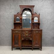 An Edwardian mahogany mirror back sideboard with a carved and moulded arched pediment on turned