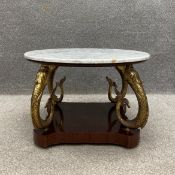 A 19th century style coffee table having a circular marble top raised on four gilt metal dolphins on