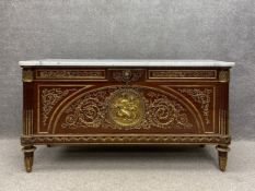A Louis XVI style mahogany commode with profuse all-over ormolu mounts having a white marble top