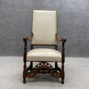 A Louis XIII style mahogany framed salon armchair having a high back with a cream leather and stud
