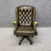 A 19th century style green faux leather button back and stud-work captain's swivel armchair with a