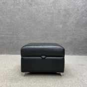A contemporary black leather upholstered footstool with a lidded storage compartment raised on