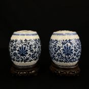 A pair of 20th century Chinese blue and white porcelain barrel form jars with reticulated covers and