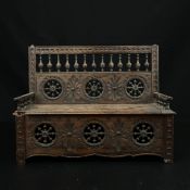 A miniature hand carved 19th century French Breton bench box having a carved and turned spindle back