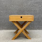 A contemporary Wem oak side table with a single frieze drawer raised on stretchered x-frame supports
