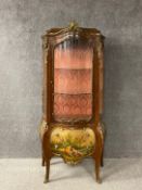 A Louis XV style vitrine or display cabinet having an arched caddy topped cornice mounted with an