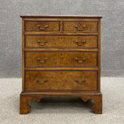 A Georgian walnut chest of drawers of small size having a moulded book matched top above two short