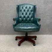 A 19th century style green leather button back and stud-work captain's swivel armchair on five