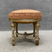 A 19th century Gustavian style stool having a round needlework cushioned top raised on carved and