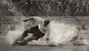 A photograph of footballer Tom Finney titled 'Splash' by Johnny Horton, signed by Finney, framed and