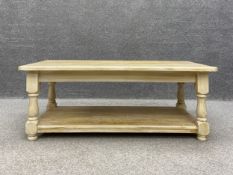 A 20th century painted pine coffee table having a rectangular top raised on turned and carved