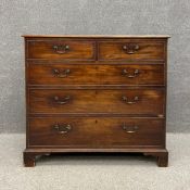 A Georgian mahogany chest of two short over three long cockbeaded drawers raised on shaped bracket