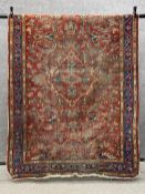 A Persian Heriz carpet having a central lozenge medallion among scrolling foliate designs over an