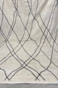 A large contemporary Morocco Hali carpet having an abstract line-work lattice pattern over a biscuit
