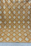 A large handwoven carpet having an allover repeating white and ochre foliate needlework pattern over
