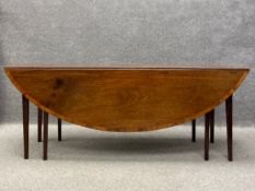 A Georgian mahogany drop flap table having an oval crossbanded top with a central cartouche and a