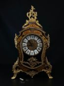 A Franz Hermle & Sons red boulle brass inlaid Louis XV style mantle clock having a gilt metal Rococo