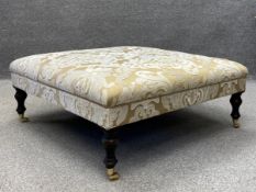 A large contemporary Victorian style footstool having a square cushioned footrest in a bronze