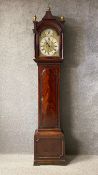 A Georgian mahogany longcase clock having a shaped cornice with three brass finials over a moulded
