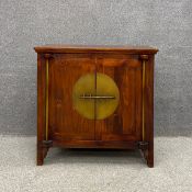 A contemporary Chinese fruitwood sideboard or Kang cabinet having moulded top above two brass