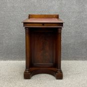 A mid 19th century mahogany davenport having a tooled and gilt leather slope with a moulded edge