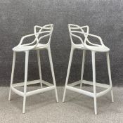 A pair of contemporary Italian Modernist style white moulded composite Masters Stools of curvilinear