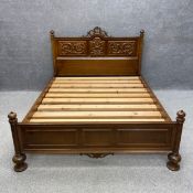 A mahogany double bedstead in the 19th century Italian style having a shaped headboard with a