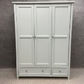 A contemporary three door combination wardrobe in duck egg blue having a square cornice over three