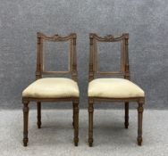 A pair of 19th century French walnut side chairs each having a curved top rail with a carved harp