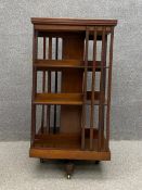 A large Edwardian mahogany revolving bookcase having a square moulded top over three tiers of
