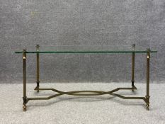 A 20th century Hollywood Regency style coffee table having a rectangular plate glass top raised on