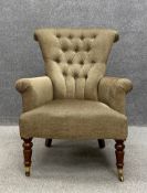 A 19th century button back library armchair having a splayed scrolling back with curved arms over