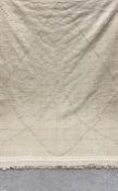 A large flat-weave Kilim carpet having a taupe needlework lattice pattern over an oat ground with