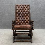 A Victorian mahogany button back rocking chair having a brown leather deep buttoned upholstered back
