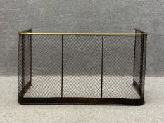 A Victorian fire guard having a brass d-end top rail over a latticework mesh frieze raised on a