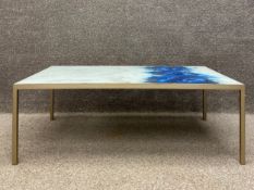 A 20th century coffee table having a rectangular glass top sandwiching a marble effect dyed sheet