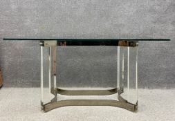 A 1970's Italian dining table having a rectangular plate glass top raised on a polished brass and